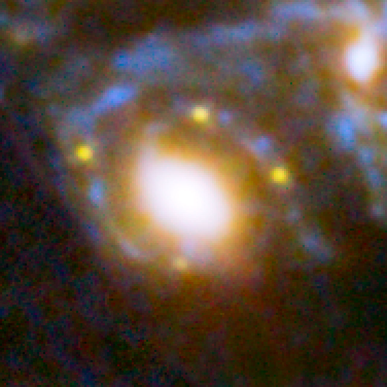 This image shows four different images of the same supernova whose light has been distorted and magnified by the huge galaxy cluster MACS J1149+2223 in front of it. The huge mass of the cluster and one of the galaxies within it is bending the light from a supernova behind them and creating four separate images of the supernova. The light has been magnified and distorted due to gravitational lensing and as a result the images are arranged around the elliptical galaxy in a formation known as an Einstein cross.